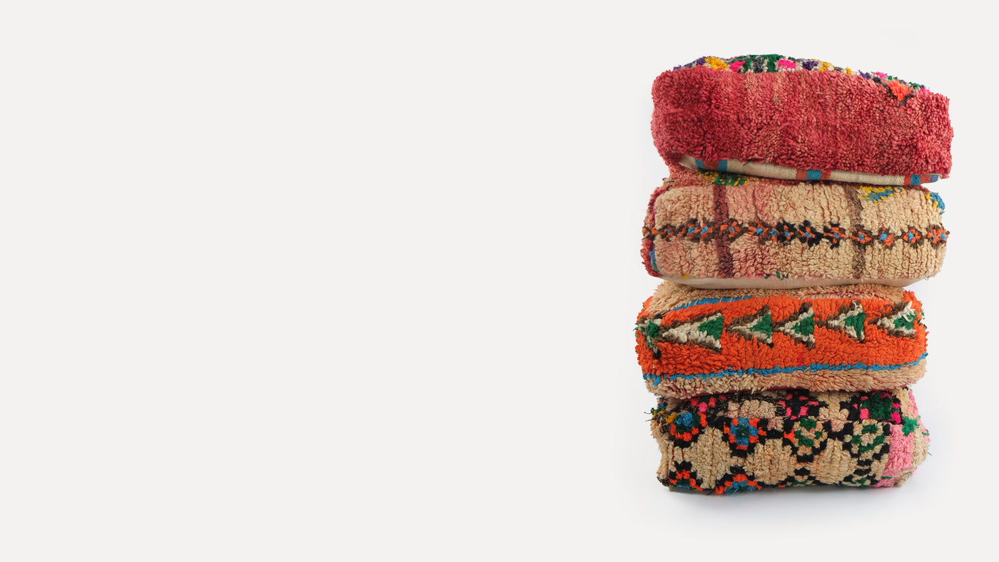 stack of 4 wool floor cushions made from sections of hand loomed Moroccan rugs